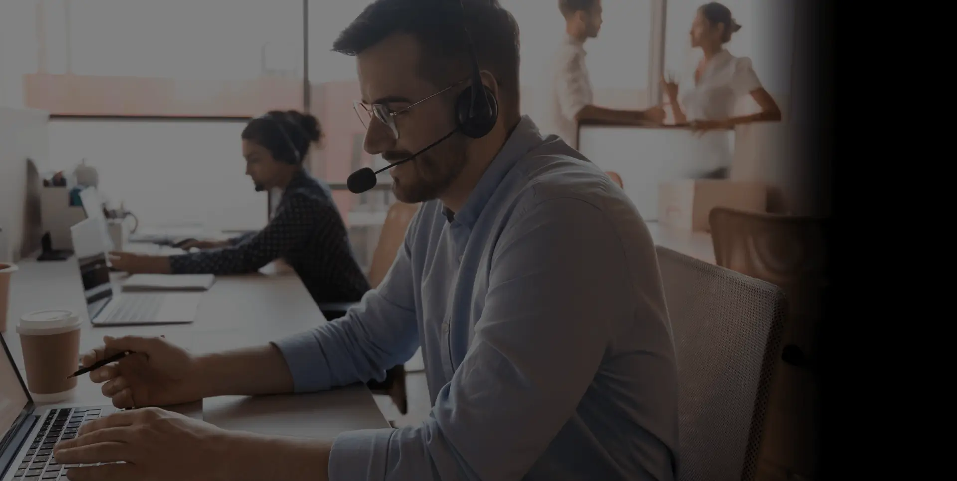 Sekure call centre employee at their workstation talking on the phone with a customer and helping them with their account