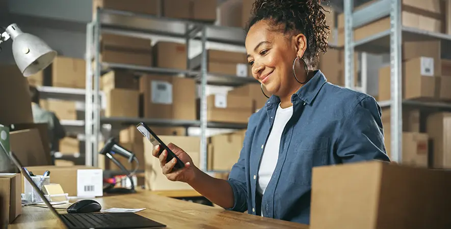 Warehouse manager reviews inventory numbers from their mobile phone
