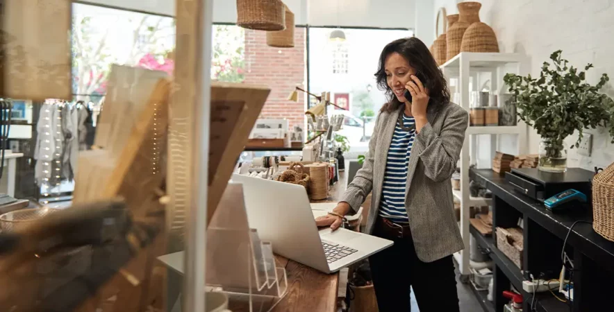 Business owner reviewing the payment processing from a laptop in their shop.