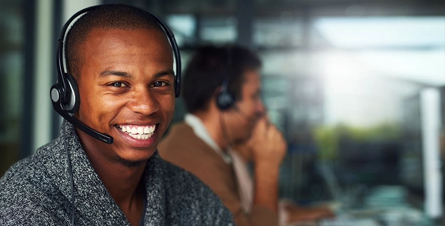 Payment Expert working on custom payment processing solutions in an office with colleagues in the background.