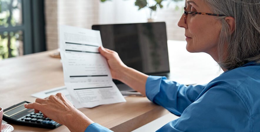 Business woman calculating Elavon’s hidden fees.