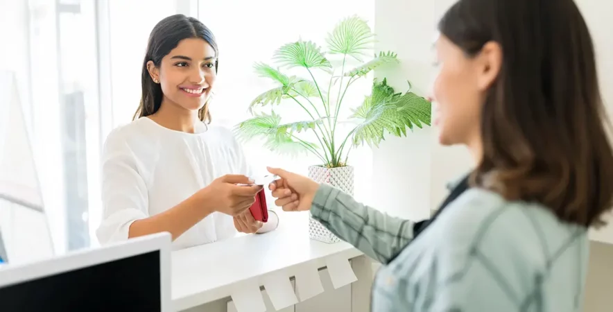 Spa receptionist receiving payment from happy customer.