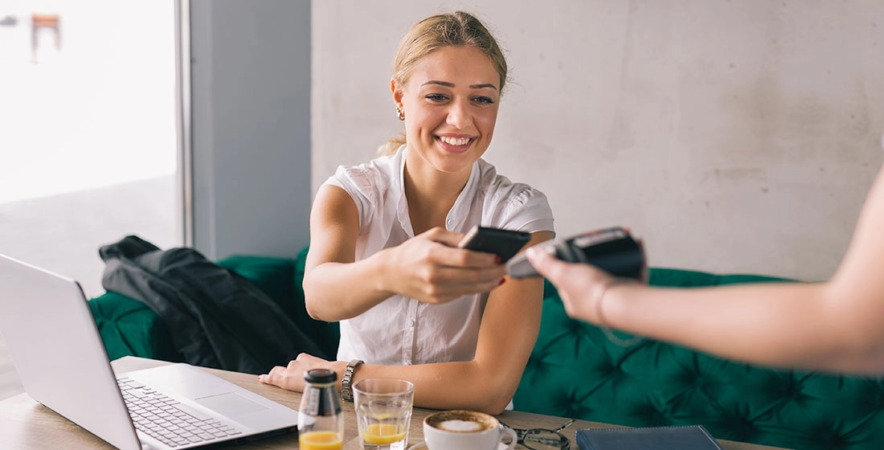 Happy customer making mobile payment at cafe.