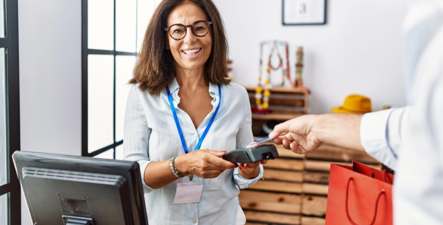 Small business owner receiving contactless payment on POS system.