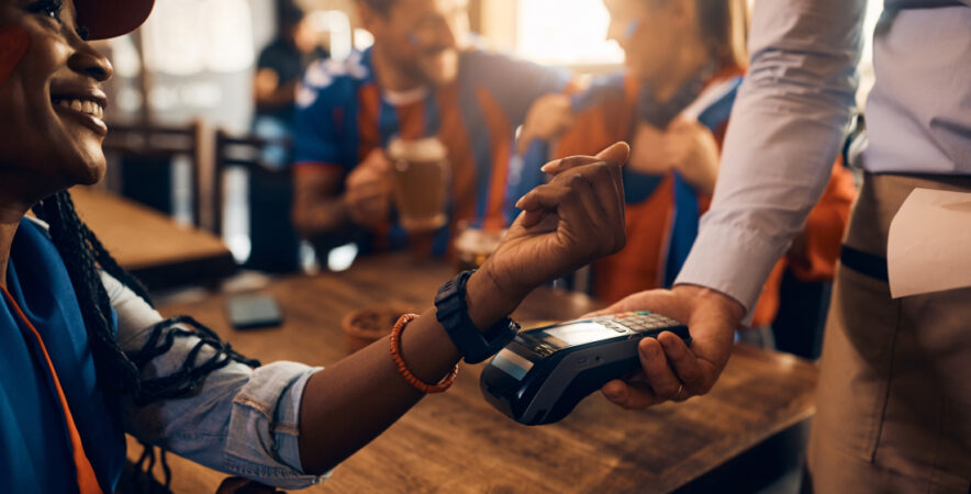 Customer making contactless payment with a wearable device.