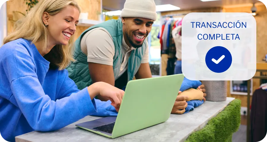 Dueños de negocio revisando una transacción en línea desde una laptop